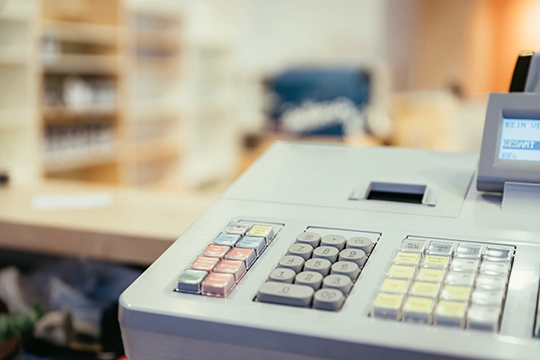 Kasa fiskalna na ladzie w punkcie sprzedaży.